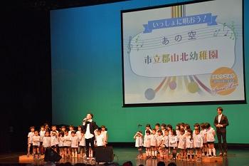 ステージ上で合唱をしている幼稚園児たちの様子の写真
