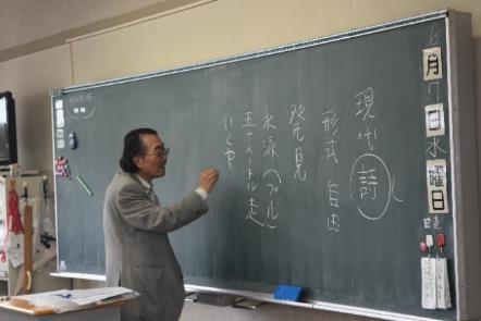 黒板に詩を書きながら詩の授業をしている特別講師の先生の様子の写真