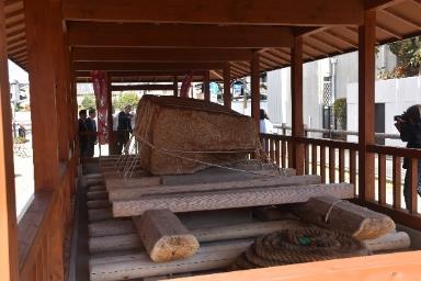 木造りの修羅と修羅に乗っている大きな石の写真