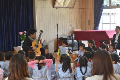 園児の前で大萩康司さんがギターを演奏している写真