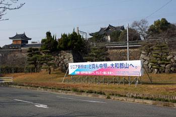 里山を背景に「リニア新駅は、ど真ん中駅、大和郡山へ。」と書かれた横看板の写真