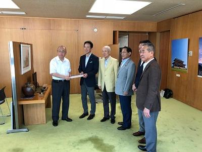 決議書を手渡す5人の男性の写真