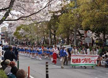 青いスカートを履いた女性たちがパレードしている写真