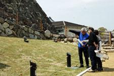 大和郡山城の石垣を前に、来訪者へ解説を行う「石垣の語り部」の写真