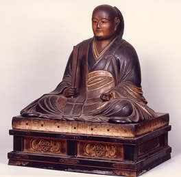 笏を持ち台座のうえに坐している、筒井順慶坐像の写真