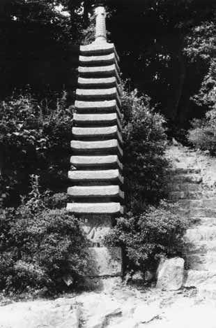 石段と木々とともに撮影された十三重石塔の写真
