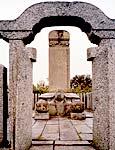 石の扉をつけた門越しに大きな亀の台とそのうえの石碑を収めた歌ヶ崎廟の写真