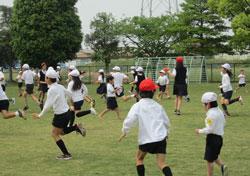 治道小学校のイメージ写真。生徒が校庭で運動にはげんでいる様子がうかがえる