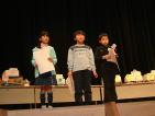 舞台上で表彰状を手に立っている少年少女3人の写真