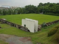 広い芝生の上に塀が設置されている配水池の写真