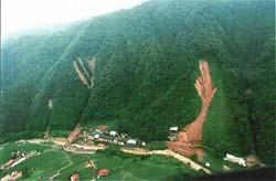 土砂崩れが起きて山肌の一部が茶色く露出している緑の山の写真