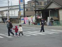 横断歩道を手を繋いで歩く親子を横から撮った写真